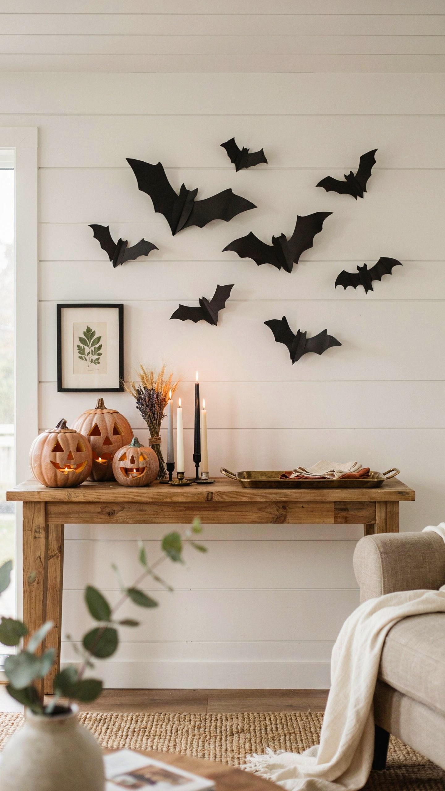Black paper bat wall decoration creating an easy DIY Halloween display in a cozy living room.